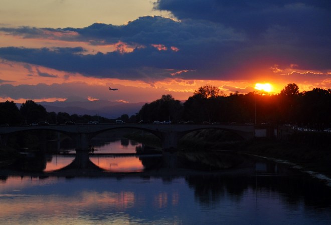 A plane departs as the sun sets